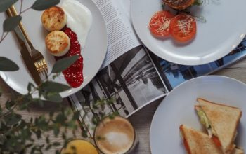 Overhead view of a stylish breakfast setup with toast, pastries, and beverages.